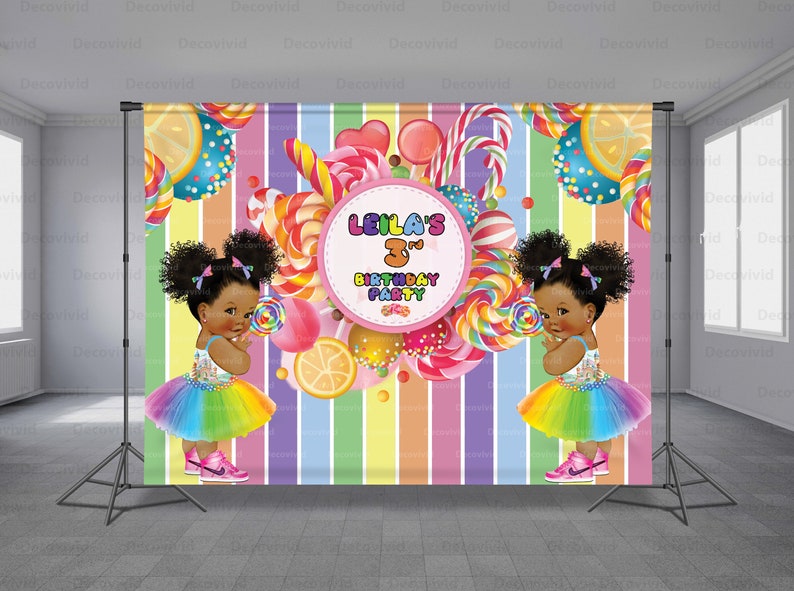 Pu&ograve; includere: Uno sfondo colorato a tema caramelle per una festa di compleanno. Lo sfondo presenta uno sfondo a strisce arcobaleno con caramelle colorate, lecca-lecca e fette di limone. Due bambine con tut&ugrave; arcobaleno e codini tengono lecca-lecca. Il testo "Leila's 3rd Birthday Party" &egrave; in un cerchio rosa.