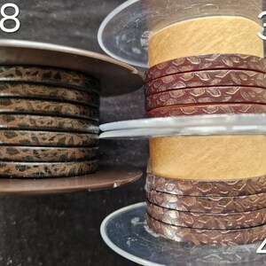 May include: Three plastic spools holding flat leather cord. Spool 38 features a dark brown cord with a black speckled pattern. Spool 39 displays a reddish-brown cord with a textured snake-skin pattern. Spool 40 shows a dark brown cord with a textured pattern.