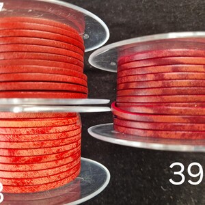 Pu&ograve; includere: Tre bobine di cordoncino in pelle rossa. Il cordoncino &egrave; avvolto in strati piatti e circolari. I numeri 37, 38 e 39 sono visibili sull'immagine. Il cordoncino appare di un colore rosso intenso e ricco.