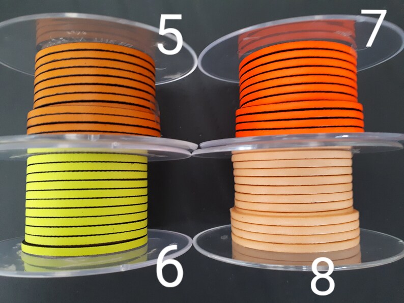 Pu&ograve; includere: Sono mostrate quattro bobine di nastro. Due bobine sono arancioni con strisce nere, una &egrave; gialla con strisce nere e una &egrave; beige. Le bobine sono su supporti di plastica trasparente.