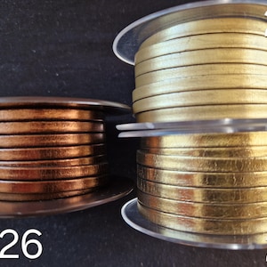 Pu&ograve; includere: Tre bobine di cordino in pelle piatta etichettate 26, 27 e 28. La bobina 26 &egrave; di colore bronzo metallizzato. La bobina 27 &egrave; di colore oro opaco. La bobina 28 &egrave; di colore oro lucido e riflettente. Ogni bobina &egrave; avvolta con pi&ugrave; strati di cordino.