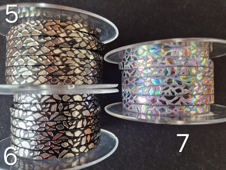 May include: Three spools of flat cord labeled 5, 6, and 7. Spool 5 features a black cord with a metallic gold mosaic pattern. Spool 6 displays a black cord with a metallic silver mosaic pattern. Spool 7 shows a white cord with an iridescent mosaic pattern.