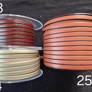 Pu&ograve; includere: Tre bobine di cordino in pelle piatta. La bobina 23 presenta una pelle testurizzata marrone scuro. La bobina 24 &egrave; un cordino in pelle color oro metallizzato. La bobina 25 &egrave; una bobina pi&ugrave; grande di pelle liscia color marrone chiaro.