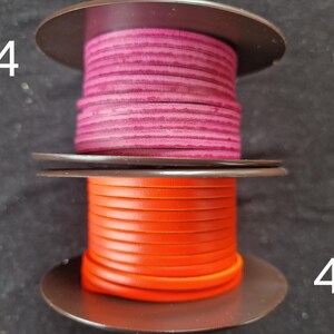 Pu&ograve; includere: Due bobine di cordoncino in pelle. La bobina superiore &egrave; di colore magenta intenso e la bobina inferiore &egrave; arancione brillante. Le bobine sono su uno sfondo scuro. I numeri 44 e 45 sono visibili sui lati sinistro e destro.