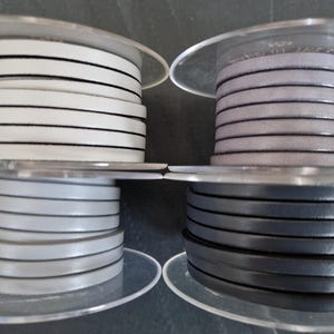 Pu&ograve; includere: Quattro rocchetti di cordino in pelle piatta etichettati 9, 10, 11 e 12. Il rocchetto 9 &egrave; bianco, il 10 &egrave; grigio chiaro, l'11 &egrave; grigio lavanda tenue e il 12 &egrave; grigio antracite scuro. Ogni rocchetto contiene una lunghezza continua di cordino.