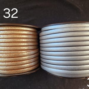 Pu&ograve; includere: Due bobine di cordino in pelle rotondo. La bobina a sinistra &egrave; contrassegnata dal numero 32 e presenta un cordino color rame metallizzato con finitura testurizzata. La bobina a destra &egrave; contrassegnata dal 33 e presenta un cordino in pelle argento opaco.