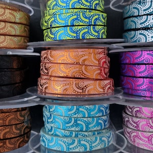 Peut inclure: Assortiment de cordons en cuir colorés avec un motif en spirale. Le cordon est enroulé autour de bobines.