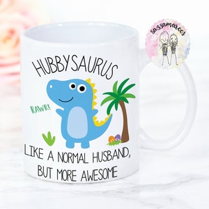 May include: White ceramic mug with a blue dinosaur illustration and the text "Hubbysaurus, Rawr! Like a normal husband, but more awesome".