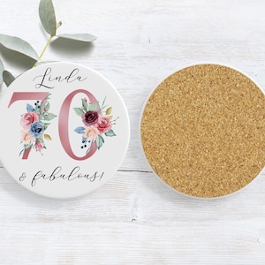 Puede incluir: Posavasos de cer&aacute;mica blanca con un dise&ntilde;o floral rosa y el texto "Linda 70 & fabulosa!"
