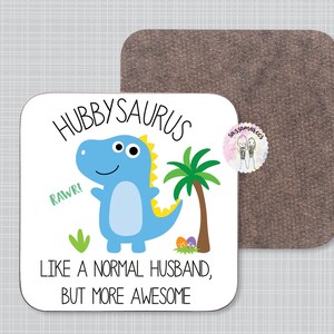 May include: White coaster with a blue dinosaur cartoon illustration and the text "Hubbysaurus, Rawr! Like a normal husband, but more awesome".