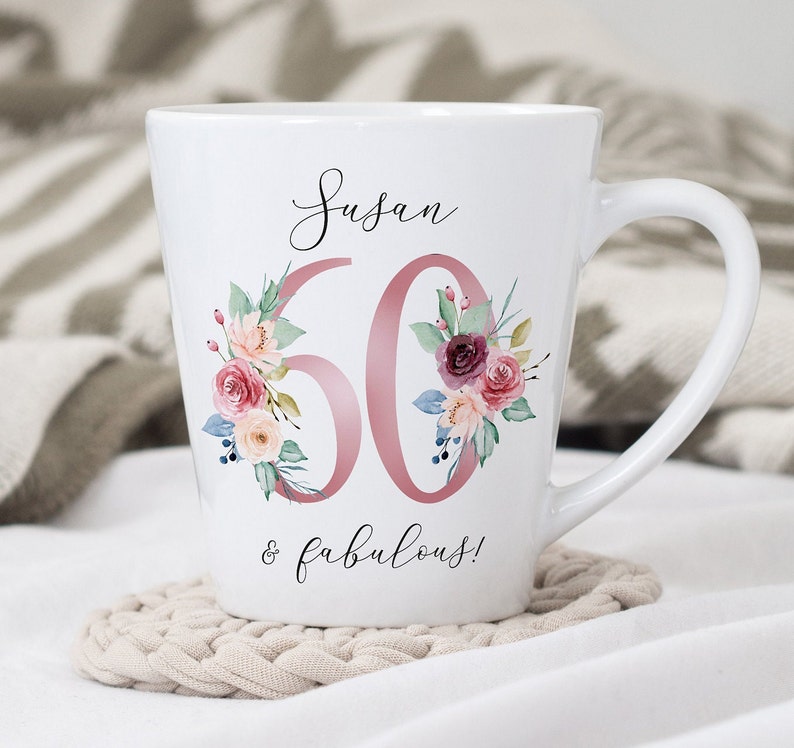 May include: White ceramic mug with a pink floral design and the text "Susan 60 & fabulous!"