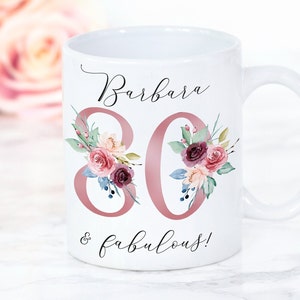 Pu&ograve; includere: Tazza in ceramica bianca con un design floreale rosa e il testo "Barbara 80 & favolosa!"