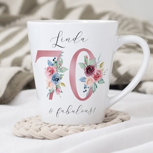 May include: White ceramic mug with a pink floral design and the text "Linda 70 & fabulous!"