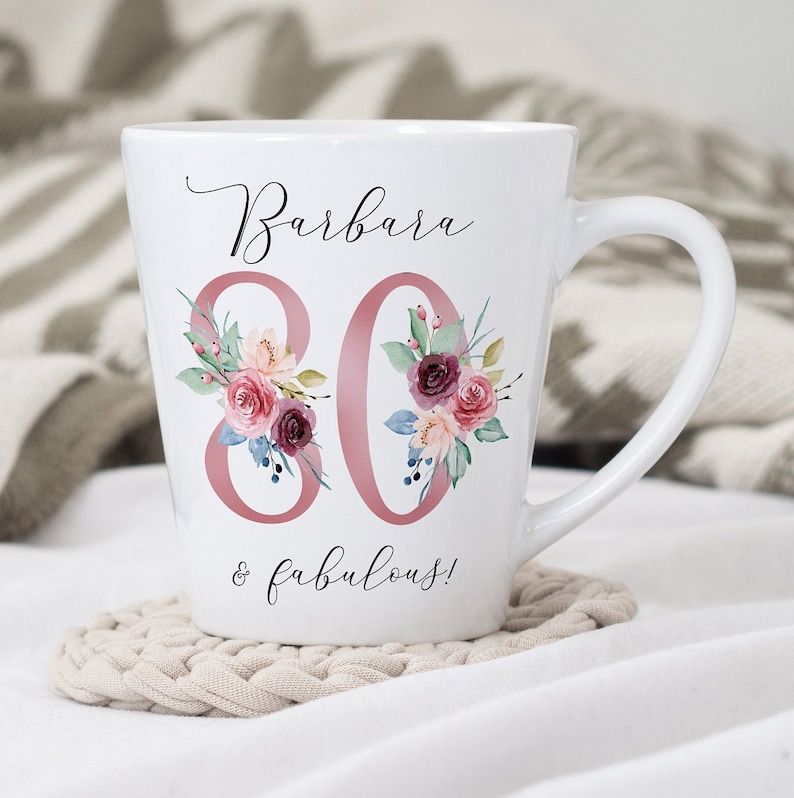May include: White ceramic mug with a pink floral design and the text "Barbara 80 & fabulous!"