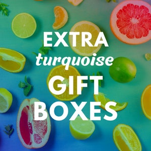 May include: A flat lay image of citrus fruits, including lemons, limes, oranges, and grapefruits, arranged on a turquoise background. The text "EXTRA turquoise GIFT BOXES" is superimposed on the image.