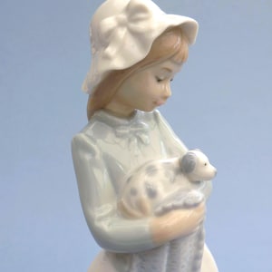 Nao Lladro figurine Sweet Girl features a young girl, her puppy and a blanket. Retired glossy Spanish porcelain, vintage collectible gift.