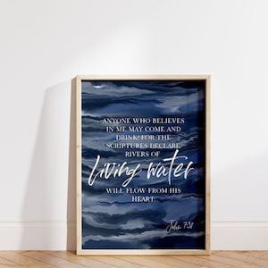 May include: A framed print with a blue watercolour background and white text that reads "Anyone who believes in me may come and drink for the scriptures declare rivers of living water will flow from his heart. John 7:38".