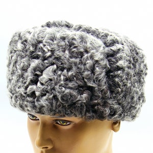 May include: A grey and white fur hat with a rounded crown and a wide brim. The hat is made of a soft, fluffy material and has a classic, traditional style.
