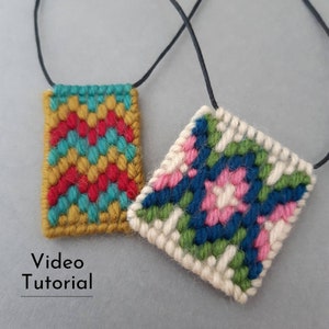 May include: Two handmade pendant necklaces. One rectangular pendant features a yellow, red, and teal chevron pattern. The other is square with a floral design in pink, green, and blue. Both are on black cords. Text: Video Tutorial.
