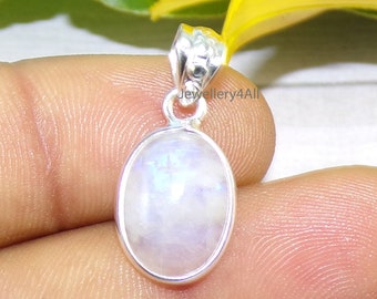 May include: A silver pendant featuring a white moonstone oval cabochon. The pendant has a simple design with a bail at the top.