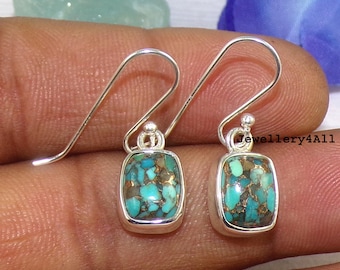 May include: A pair of silver dangle earrings with turquoise and copper inlay stones. The stones are a mix of blue, green, and brown.