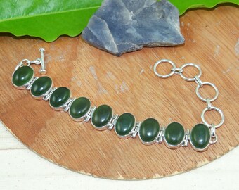 Pode incluir: Uma pulseira de prata com um design de pedra de jade verde. A pulseira tem um fecho de correr e uma corrente ajustável.