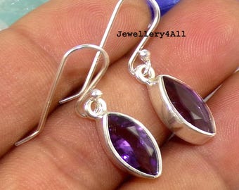 May include: A pair of silver earrings featuring purple amethyst gemstones. The earrings are teardrop shaped and set in a silver bezel.