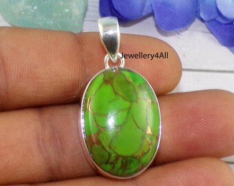May include: A green oval turquoise gemstone pendant with copper accents set in sterling silver. The pendant is on a hand.