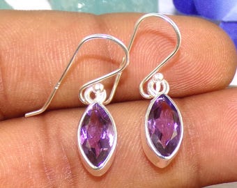 May include: A pair of sterling silver earrings featuring marquise-shaped amethyst gemstones. The earrings have a simple, elegant design and are ideal for everyday wear.