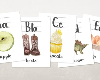 Könnte beinhalten: Vier Alphabet-Karten mit Illustrationen. Die erste Karte zeigt einen grünen Apfel mit dem Buchstaben "A" und dem Wort "Apfel". Die zweite Karte zeigt braune Stiefel mit dem Buchstaben "B" und dem Wort "Stiefel". Die dritte Karte zeigt einen gelben Cupcake mit dem Buchstaben "C" und dem Wort "Cupcake". Die vierte Karte zeigt einen grünen Dinosaurier mit dem Buchstaben "D" und dem Wort "Dinosaurier".