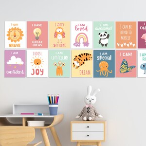 May include: A set of 12 colourful affirmation posters featuring various animals, objects, and positive messages. The posters are printed on a white background with a light pink, light blue, light green, and yellow colour scheme. The posters include messages such as "I am brave", "I am loved", "I am special", "I am unique", "I am capable", "I am just right", "I can be kind to myself", "I can!" and "Choose Joy".