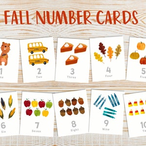 May include: Ten printable cards featuring fall-themed illustrations and numbers 1 through 10. Each card has a different image, such as a squirrel, school bus, pumpkin, and corn. The cards are white with black text and are designed for educational purposes.