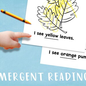 May include: A black and white illustration of a leaf and a pumpkin. The text "I see yellow leaves." and "I see orange pumpkins." is written below the illustrations. The word "EMERGENT READING" is written at the bottom of the page.
