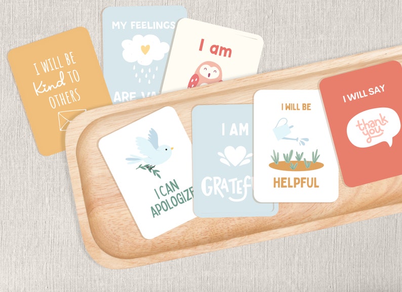May include: A set of colourful affirmation cards with illustrations and positive messages. The cards include phrases like "I will be kind to others", "I am grateful", and "I will say thank you".
