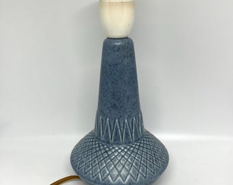 May include: A blue ceramic table lamp with a white ceramic lampshade. The lamp has a geometric pattern on the base.