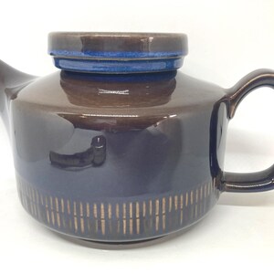 May include: A set of three ceramic mugs with a speckled, matte finish. The mugs are in shades of cream, light gray, and dark gray. Each mug has a simple, minimalist design and a rounded handle.