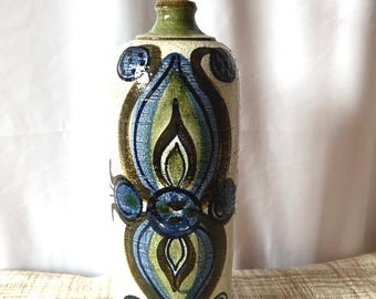 May include: A ceramic table lamp with a cream-colored base and a decorative pattern in shades of blue, green, and brown. The lamp has a cylindrical shape with a green base and top, and a white lamp holder.