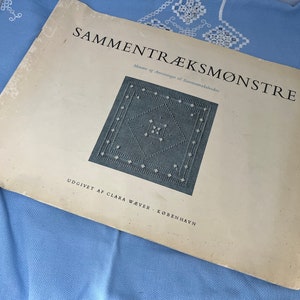 Könnte beinhalten: Ein Vintage-Buch mit dem Titel "SAMMENTRÆKSMONSTRE" mit einer Schwarzweißillustration eines Kreuzstichmusters. Das Buch wurde von Clara Waver in Kopenhagen herausgegeben.