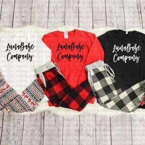 May include: Three long-sleeved shirts with the text "LunaBabe Company" in black lettering. The shirts are white, red, and black. Each shirt is paired with a pair of plaid pajama pants. The pants are red and black, black and white, and white and black.