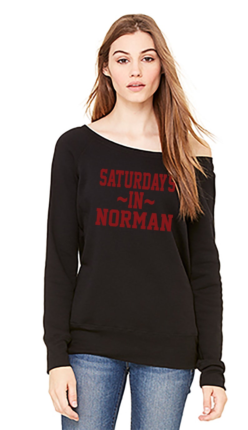 Saturdays In Norman on a classic pullover fit fleece sponge sweatshirt that can be worn pulled off the shoulder.