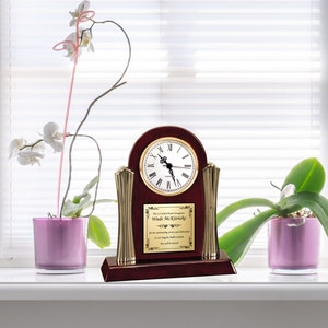 May include: A mahogany wood clock with gold accents and a brass plaque with the text "The LA School Board recognizes Wade McKirrick for his outstanding service and dedication to Los Angeles Public Schools. You will be missed."