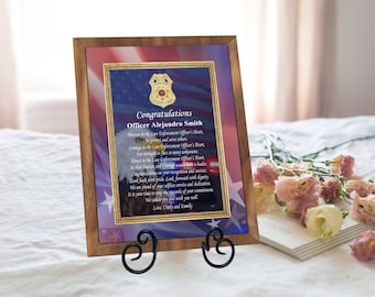 May include: A framed certificate with a gold eagle and American flag design. The certificate reads "Congratulations Officer Alejandro Smith" and includes a poem about the qualities of a law enforcement officer.