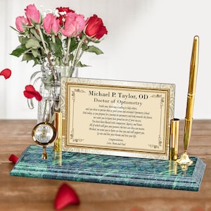 May include: A green marble desk organizer with a gold pen holder, a gold clock, and a framed certificate that reads "Michael P. Taylor, OD Doctor of Optometry".