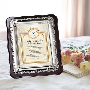 May include: A silver and mahogany framed plaque with a clock and a poem dedicated to a registered nurse named Cindy Smith. The plaque has a decorative border and a gold-colored clock face.