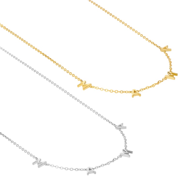 K&ouml;nnte beinhalten: Zwei zarte Halsketten mit einem Kettenmuster, jede mit den Buchstaben "MAMA" in Gold und Silber.