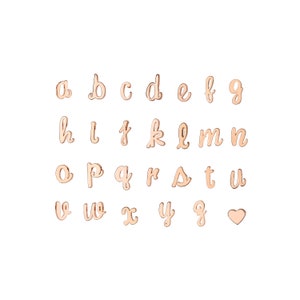 May include: A set of gold-toned metal alphabet letter charms, including a heart charm. The letters are in a cursive script font.