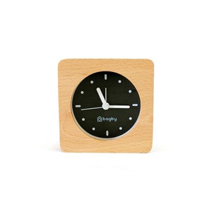 Peut inclure: Un r&eacute;veil en bois avec un cadran noir et des aiguilles blanches. Le cadran de l'horloge porte l'inscription "bagby".