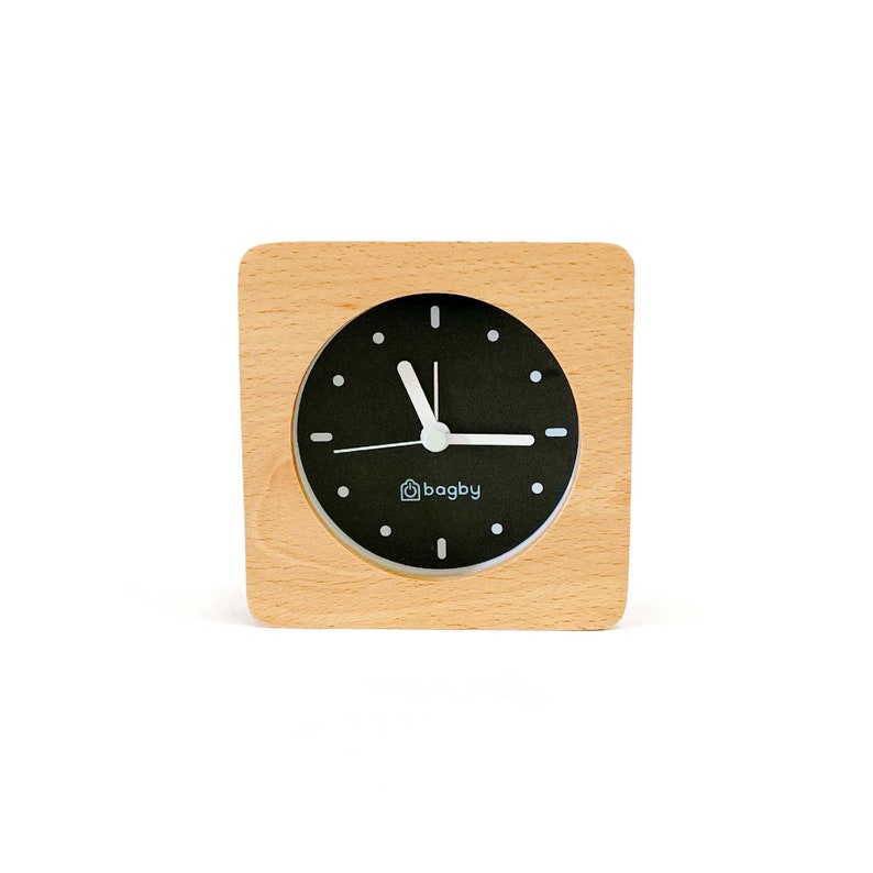 Peut inclure: Un r&eacute;veil en bois avec un cadran noir et des aiguilles blanches. Le cadran de l'horloge porte l'inscription "bagby".