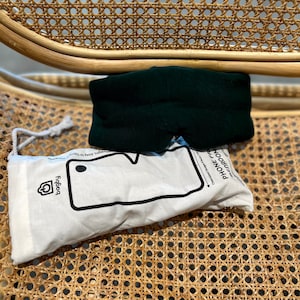 May include: A dark green sleep mask with a white pouch that says "Phone Free Zone" and has a phone outline with the text "Designed to keep you comfy" and a logo that says "Poggy".