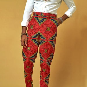 May include: Red pants with a geometric pattern in blue and gold. The pants have a slim fit and are made of a lightweight fabric.